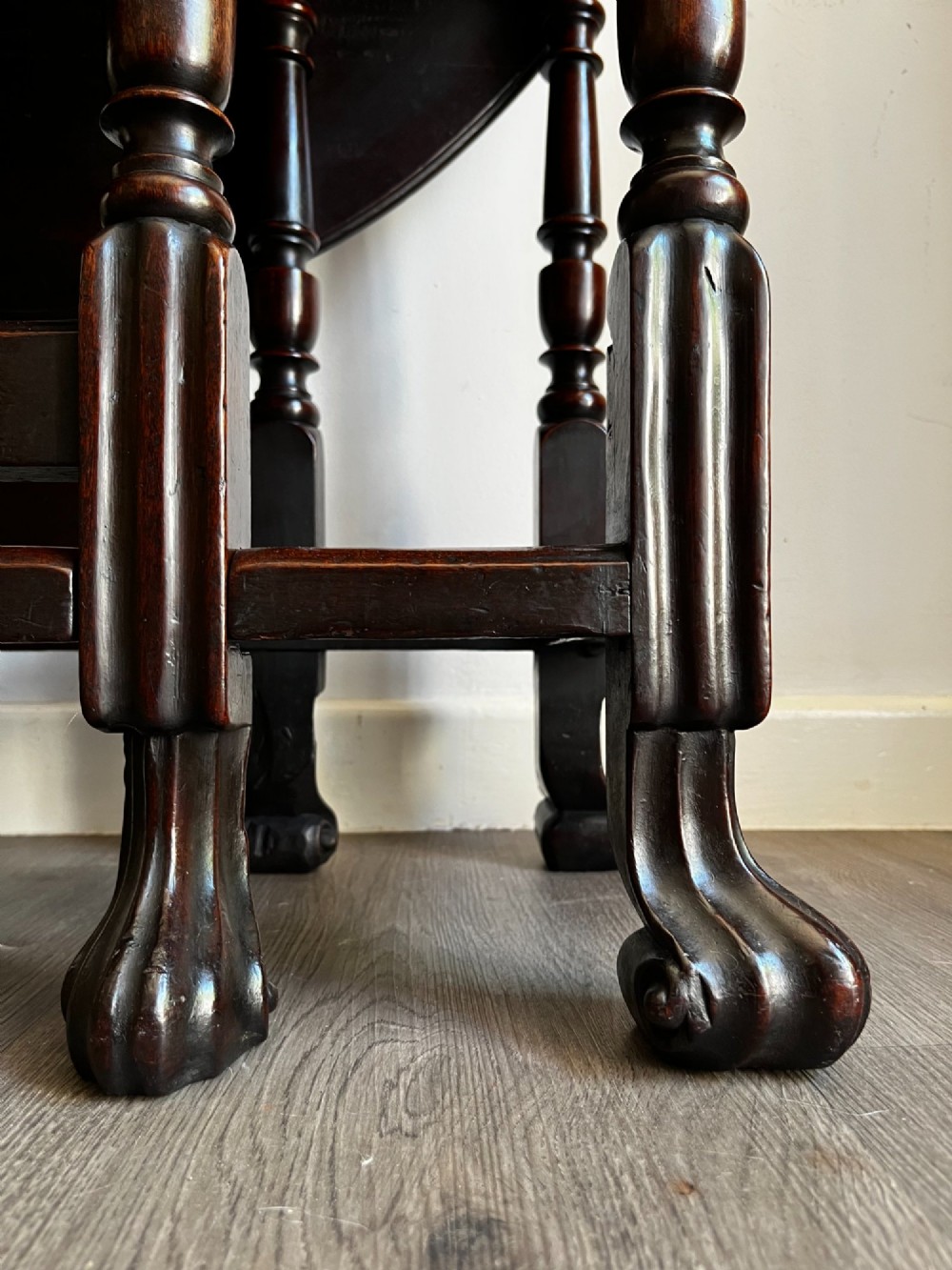A dark mahogany Georgian drop flap dining table with turned gatelegs and feet. View VII