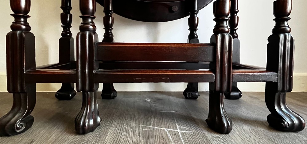 A dark mahogany Georgian drop flap dining table with turned gatelegs and feet. View VIII