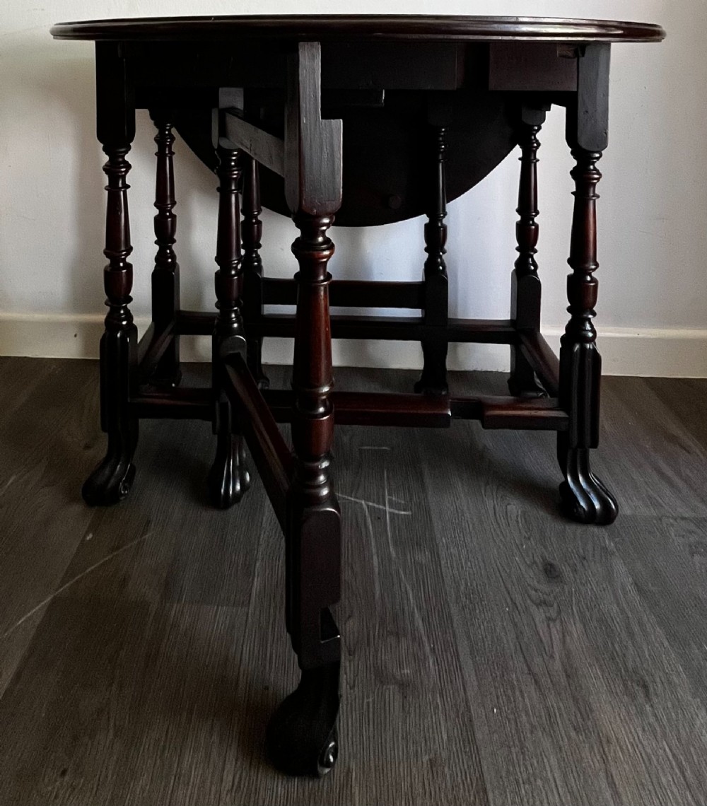 A dark mahogany Georgian drop flap dining table with turned gatelegs and feet. View IX