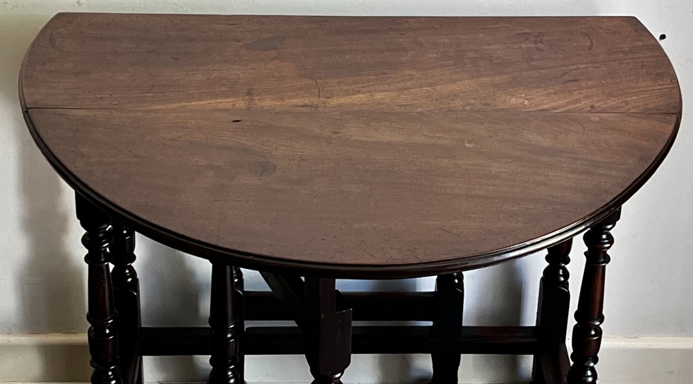 A dark mahogany Georgian drop flap dining table with turned gatelegs and feet. View X