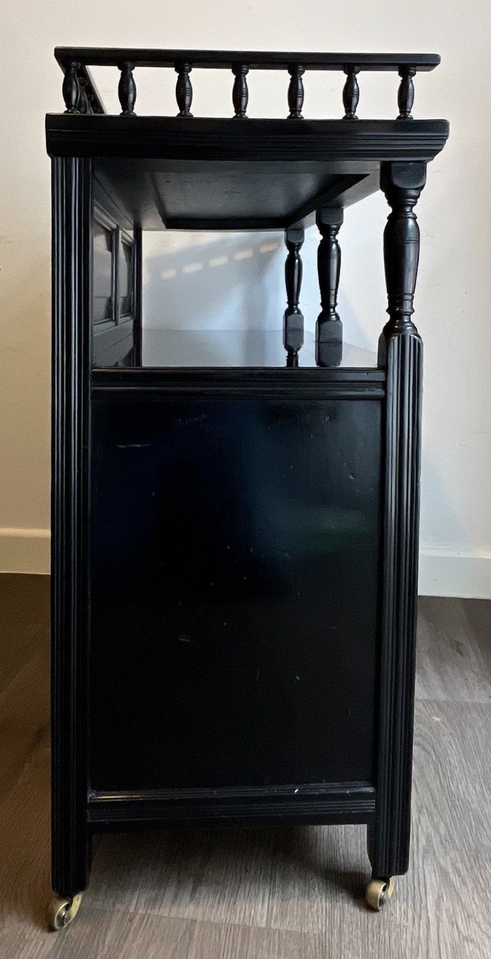 A late Victorian ebonised wood cabinet with a top spindle gallery, dark mahogany panels, and a central door featuring a profile ceramic tile of Dante. View IV
