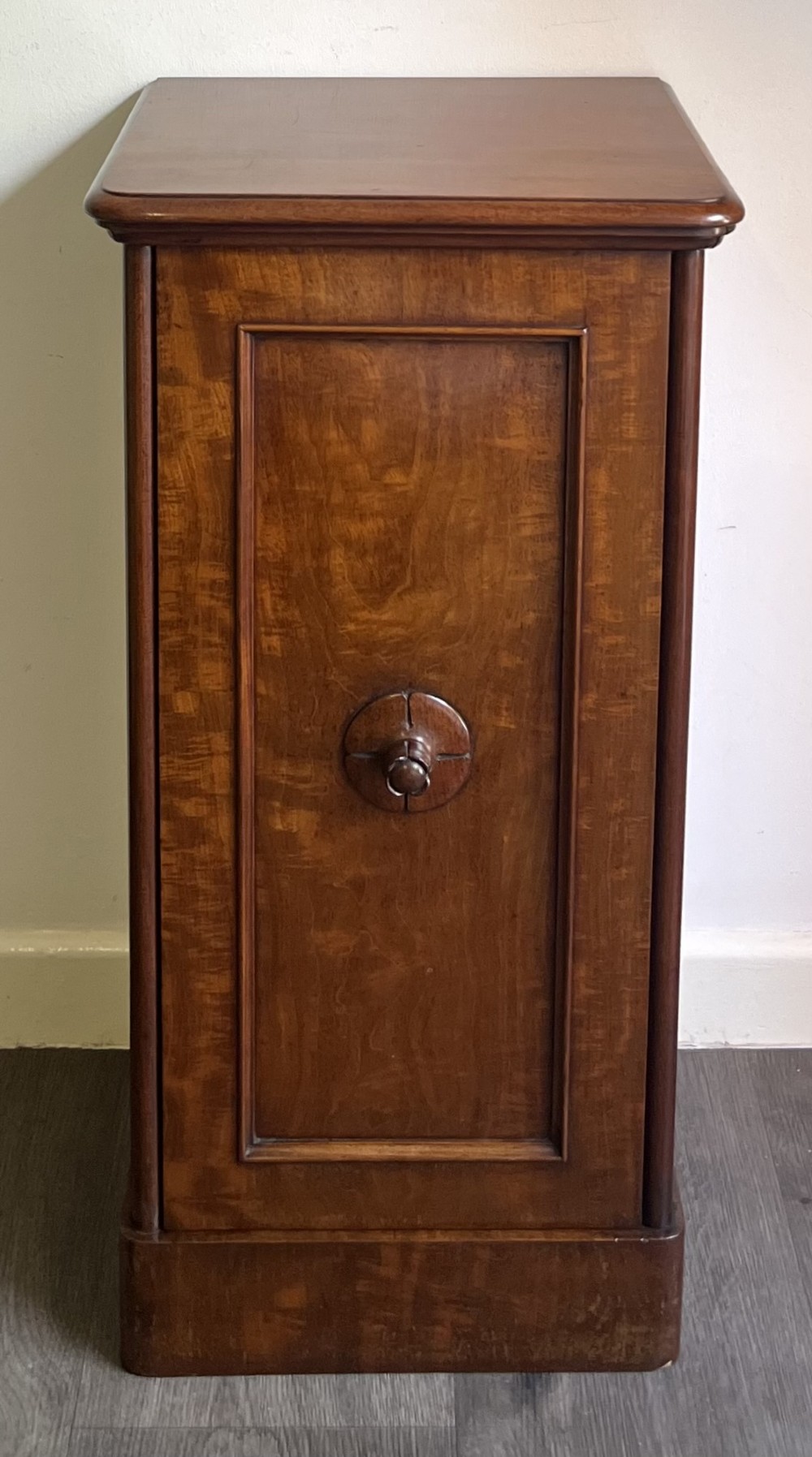 A Victorian warm brown timber pot cupboard featuring a single fielded panel door with a carved central wooden knob and a sturdy plinth base. View III