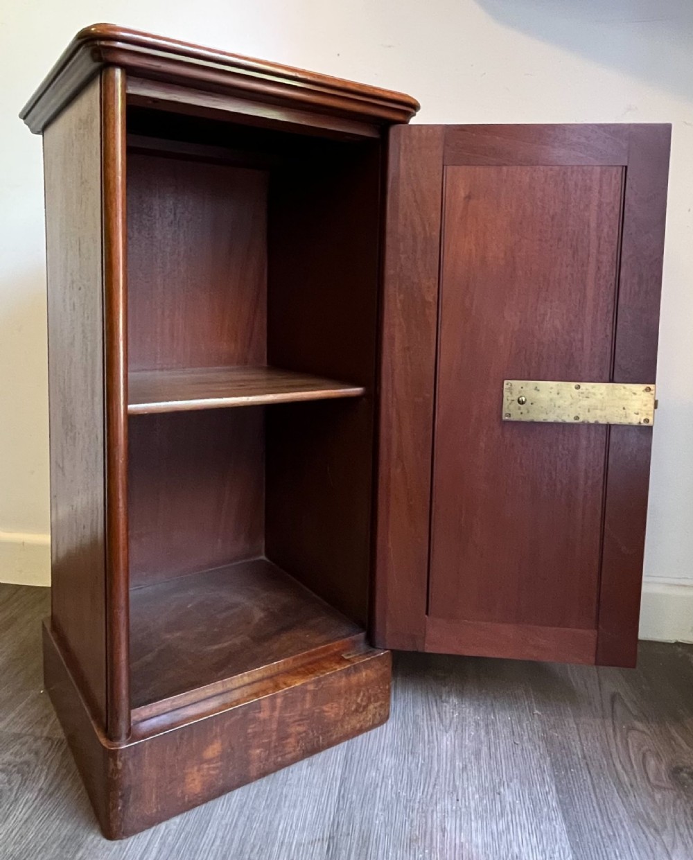 A Victorian warm brown timber pot cupboard featuring a single fielded panel door with a carved central wooden knob and a sturdy plinth base. View V