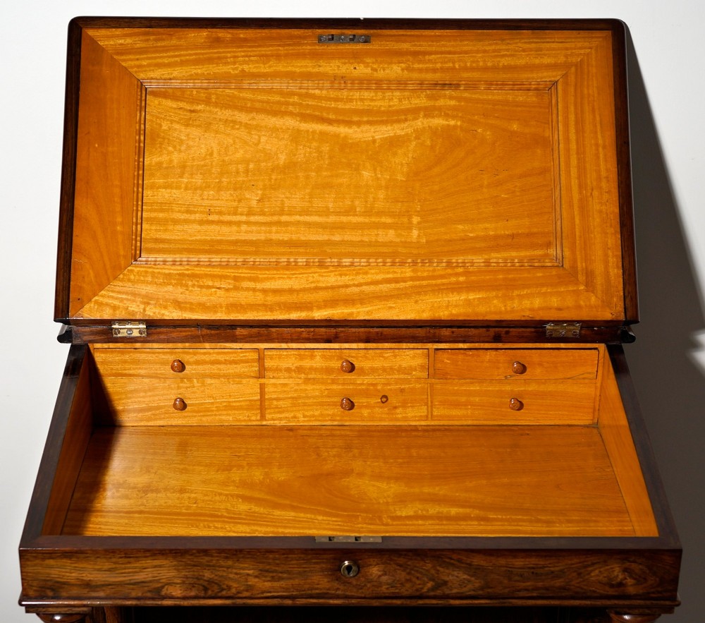 An antique dark rosewood Davenport desk featuring a slanted black leather writing surface, pierced gallery top, side drawers, and turned barley twist front columns. View II