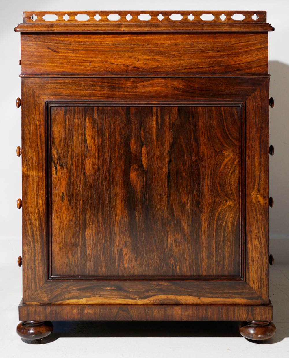 An antique dark rosewood Davenport desk featuring a slanted black leather writing surface, pierced gallery top, side drawers, and turned barley twist front columns. View VI