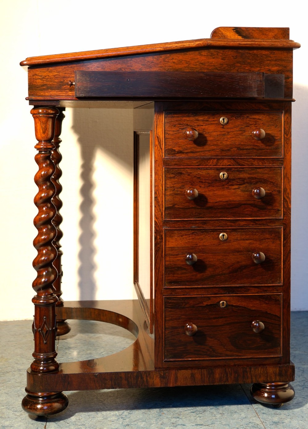 A Victorian rosewood Davenport desk featuring barley twist front supports, side drawers with wooden knob handles, and a hinged slanted top. View IV