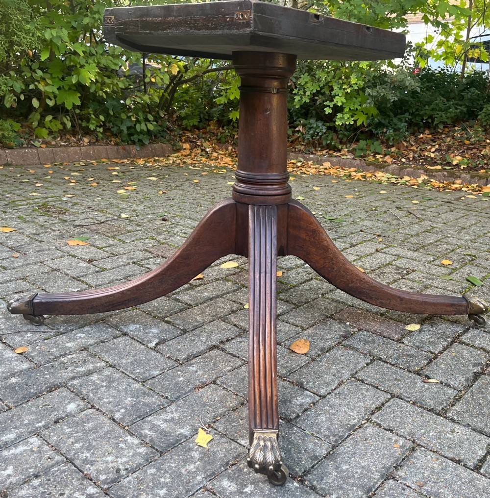 An antique wood tilt-top dining table displaying a circular crossbanded top with inlaid border on a central pedestal base. View II