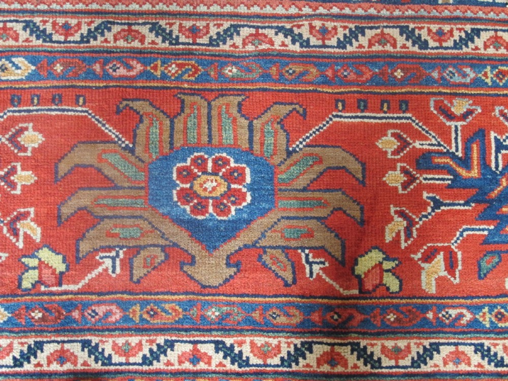 Large rectangular hand-knotted Persian Sultanabad carpet featuring a dark navy floral central field surrounded by a wide terracotta red palmette border. View IV