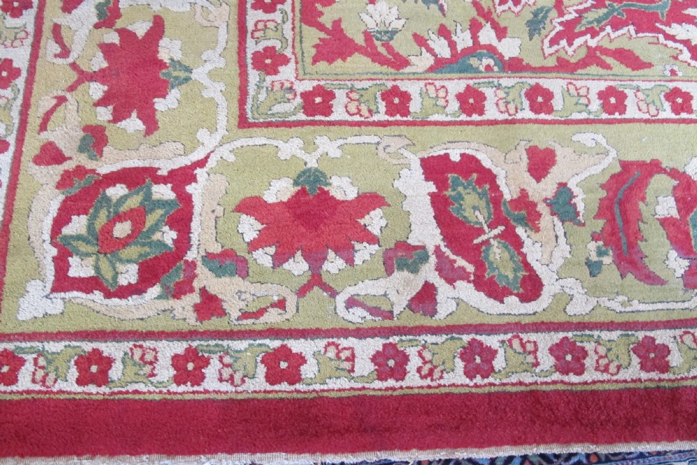 A large hand-knotted wool Amritsar carpet featuring a crimson red field decorated with olive green, cream, and pink floral vine arabesques. View II