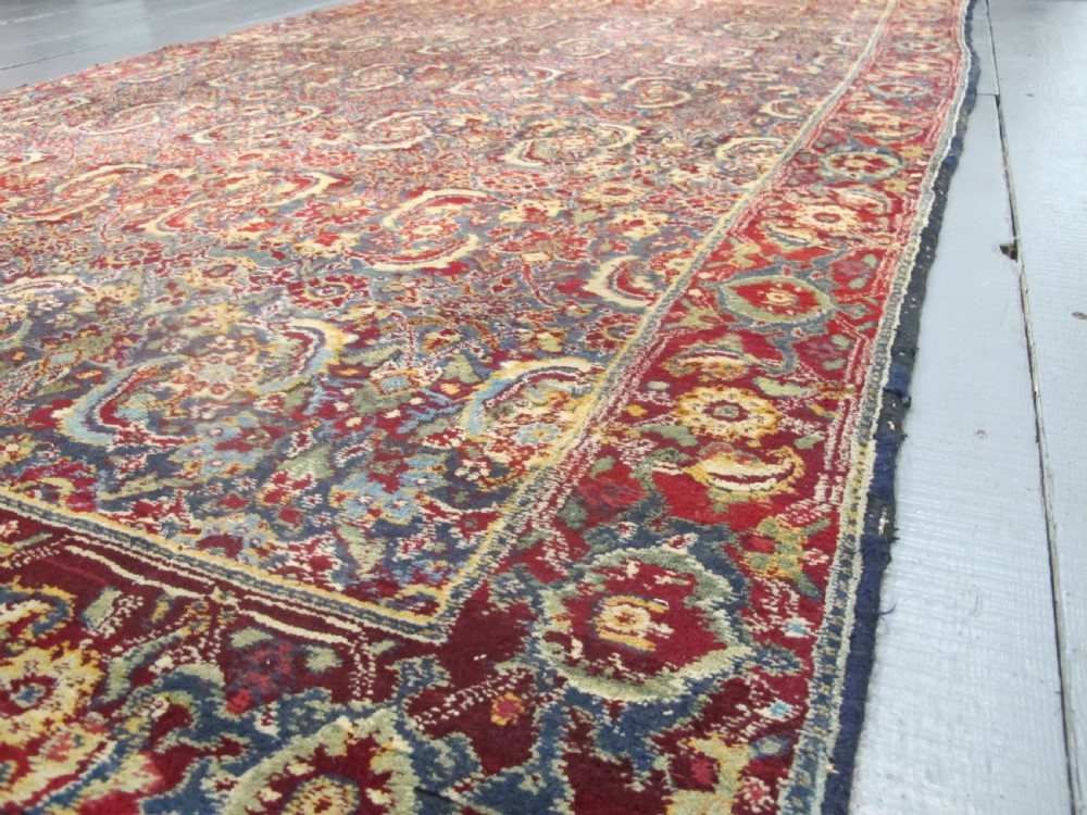 A large late 19th-century hand-knotted Agra wool carpet featuring intricate scrolling botanical motifs in crimson red, blue, and cream with a wide decorative border. View III