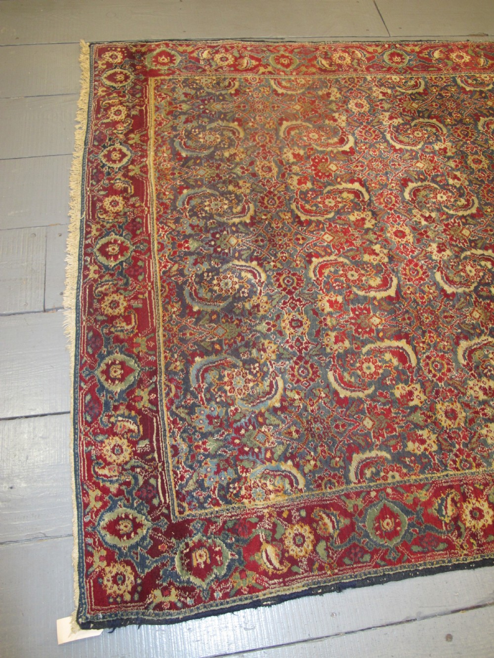 A large late 19th-century hand-knotted Agra wool carpet featuring intricate scrolling botanical motifs in crimson red, blue, and cream with a wide decorative border. View VII
