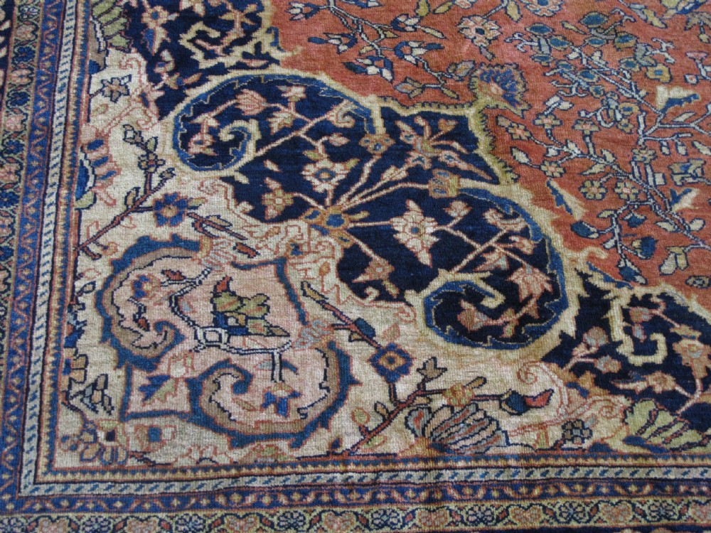 A large hand-knotted antique Persian Fereghan carpet featuring a central navy blue and ivory medallion framed by intricate floral patterns on a terracotta red field with decorative navy borders. View II