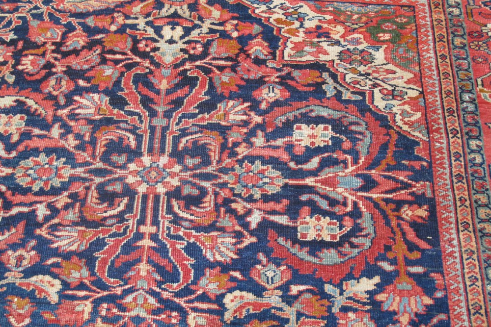 A large palace-sized antique Persian Sultanabad wool carpet featuring a deep navy blue central field, an ivory diamond medallion, intricate floral arabesques, and a broad terracotta border. View VII