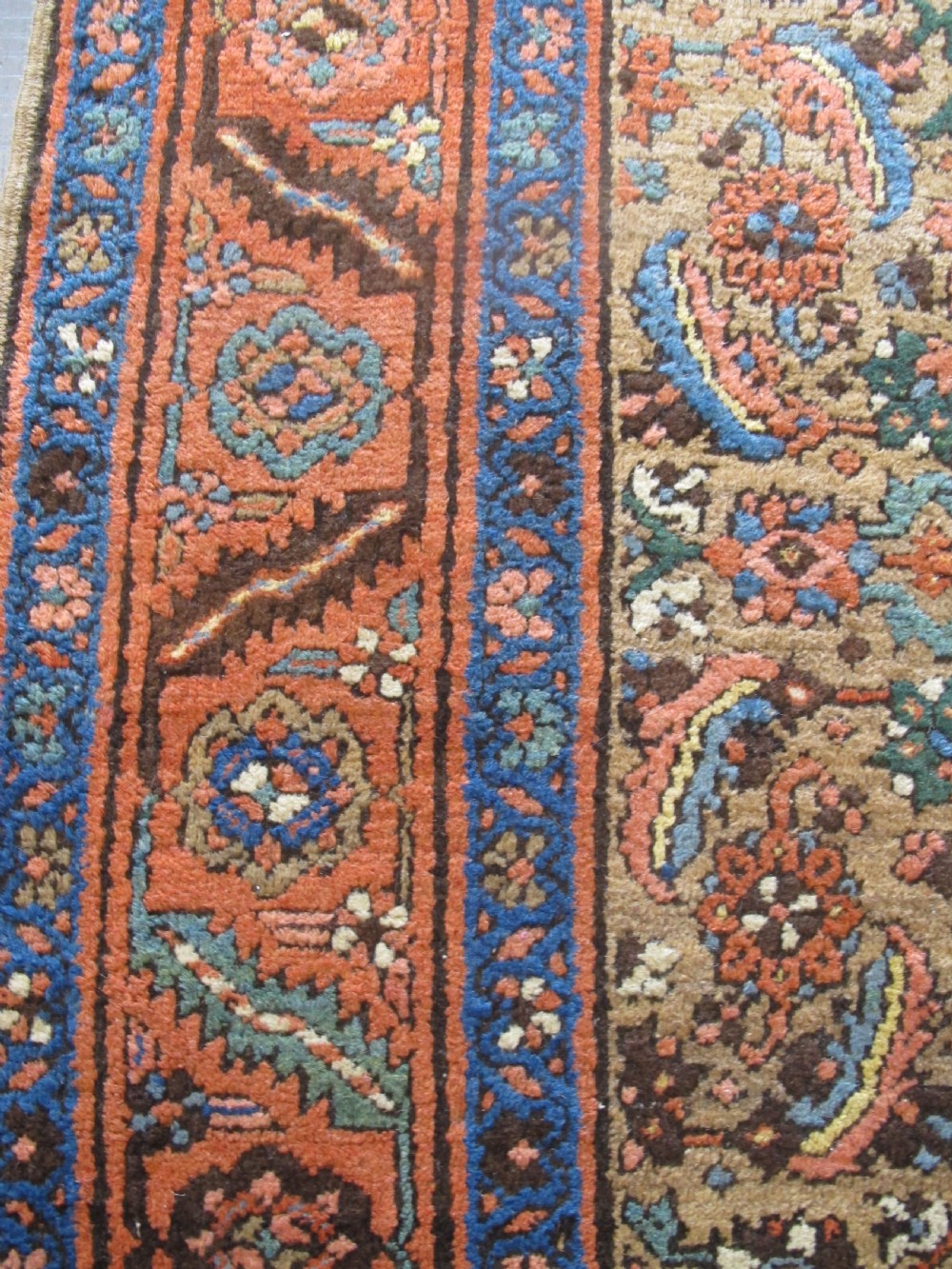 A long hand-knotted antique North-West Persian gallery carpet featuring detailed floral patterns on a camel field with terracotta borders. View III