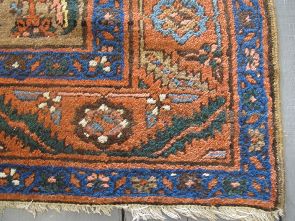 A long hand-knotted antique North-West Persian gallery carpet featuring detailed floral patterns on a camel field with terracotta borders. View V