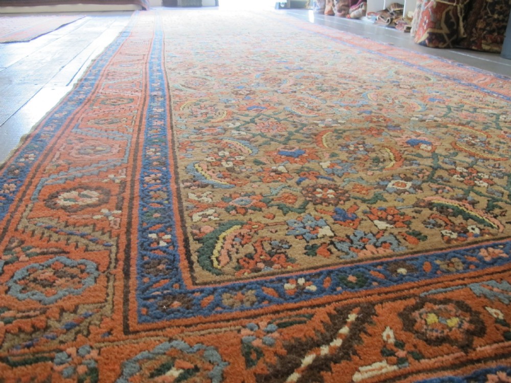 A long hand-knotted antique North-West Persian gallery carpet featuring detailed floral patterns on a camel field with terracotta borders. View VI