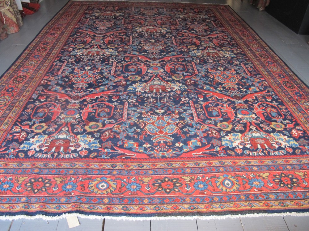 A large hand-knotted antique Persian Mahal carpet featuring a navy blue field filled with terracotta and light blue Mostafi floral patterns and a wide multi-band border. View II