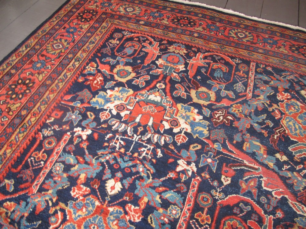 A large hand-knotted antique Persian Mahal carpet featuring a navy blue field filled with terracotta and light blue Mostafi floral patterns and a wide multi-band border. View V