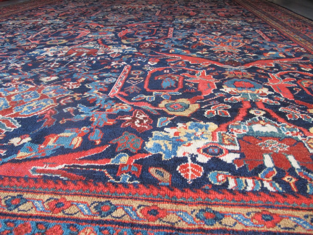 A large hand-knotted antique Persian Mahal carpet featuring a navy blue field filled with terracotta and light blue Mostafi floral patterns and a wide multi-band border. View VII