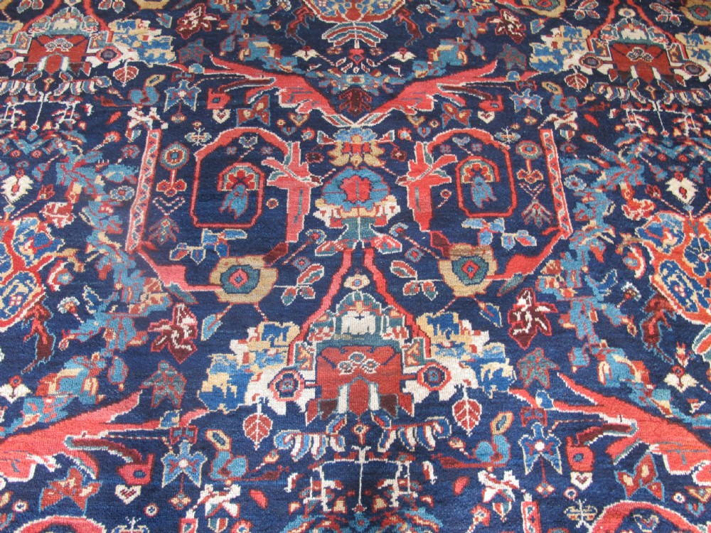 A large hand-knotted antique Persian Mahal carpet featuring a navy blue field filled with terracotta and light blue Mostafi floral patterns and a wide multi-band border. View VIII