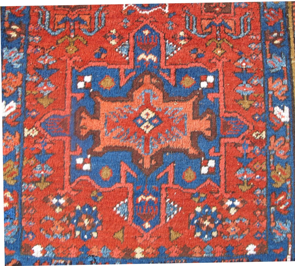 A long hand-knotted Persian Heriz wool runner rug featuring geometric medallions in shades of red, blue, and gold against a red field. View II