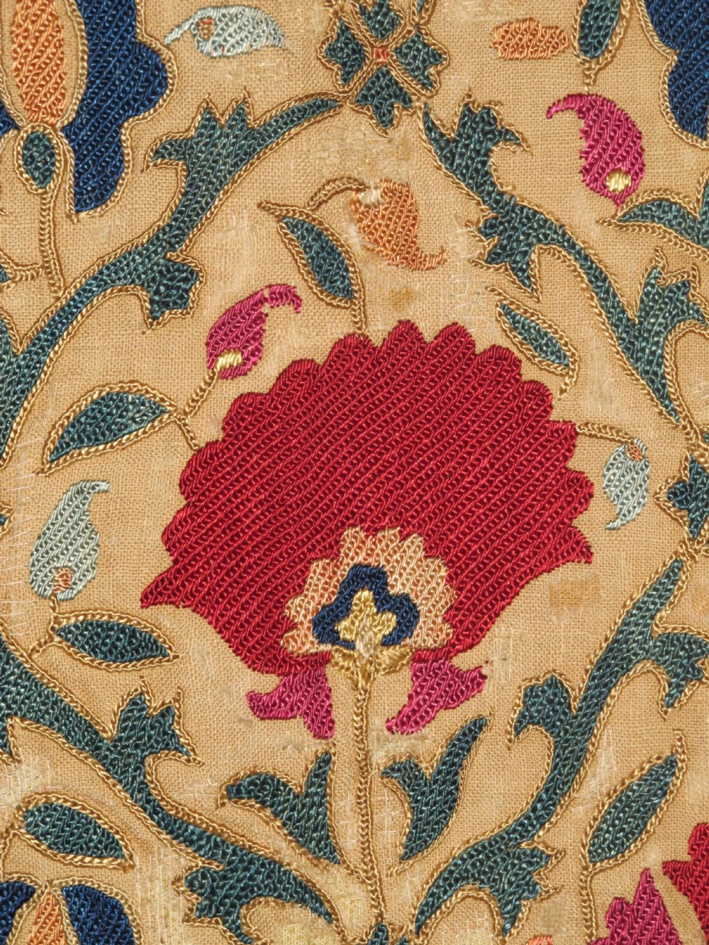 A 19th-century Bokhara suzani textile featuring red silk floral embroidery on a cream cotton ground surrounded by a wide rosette border. View II