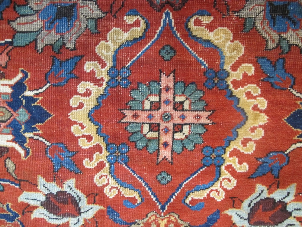 A large hand-knotted Persian Sultanabad wool carpet featuring a red central field filled with floral motifs and bordered by a wide navy band. View II
