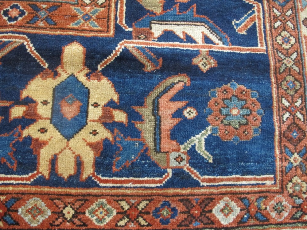 A large hand-knotted Persian Sultanabad wool carpet featuring a red central field filled with floral motifs and bordered by a wide navy band. View III