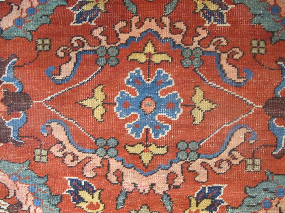 A large hand-knotted Persian Sultanabad wool carpet featuring a red central field filled with floral motifs and bordered by a wide navy band. View IV