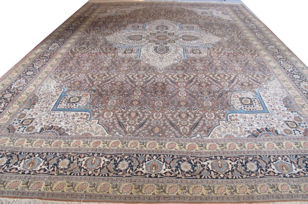 An oversized antique Haji Jalili Tabriz wool carpet featuring a central star-shaped medallion, intricate floral field, cream corner spandrels, and a multi-bordered pattern.