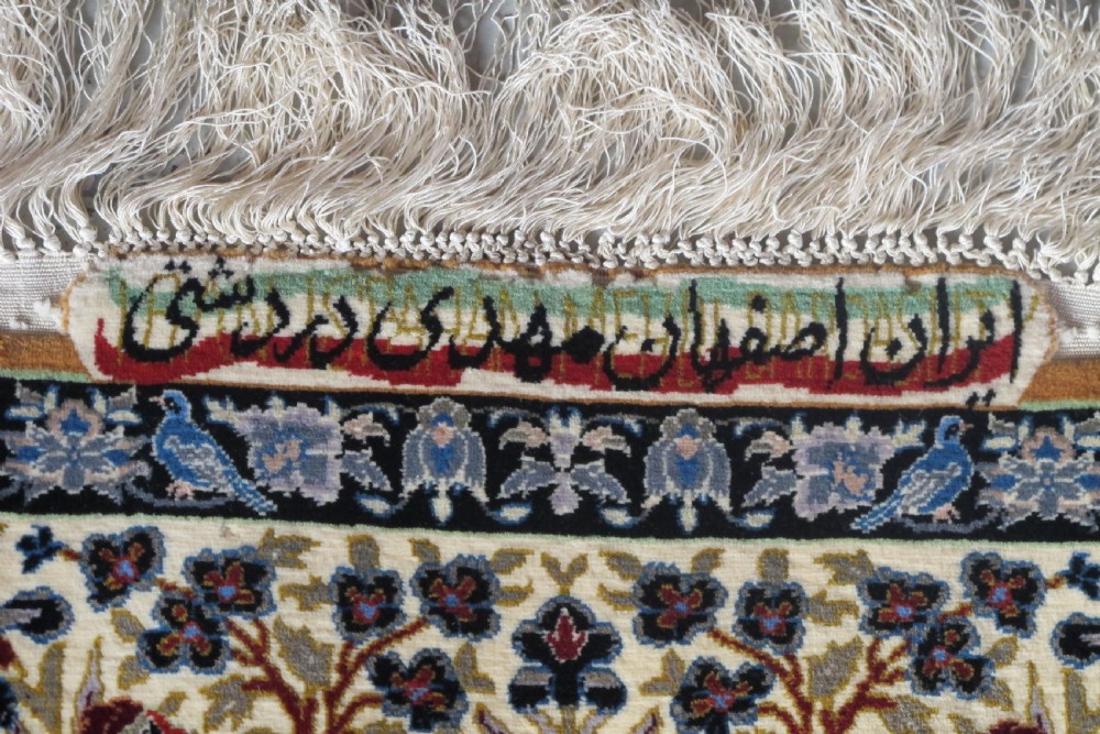 A hand-knotted Persian pictorial rug displaying figures seated beneath a blossoming tree on a sky blue field, framed by an ornate floral border. View III