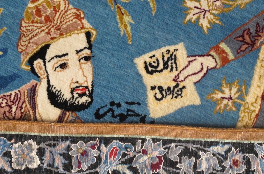 A hand-knotted Persian pictorial rug displaying figures seated beneath a blossoming tree on a sky blue field, framed by an ornate floral border. View VI