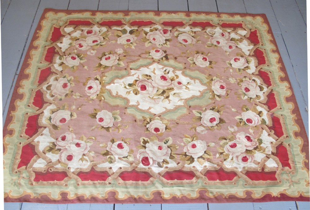A rectangular antique French Aubusson flatweave wool rug featuring a central floral medallion surrounded by rose motifs, scrollwork borders, and shades of pink, red, green, and cream. View VIII