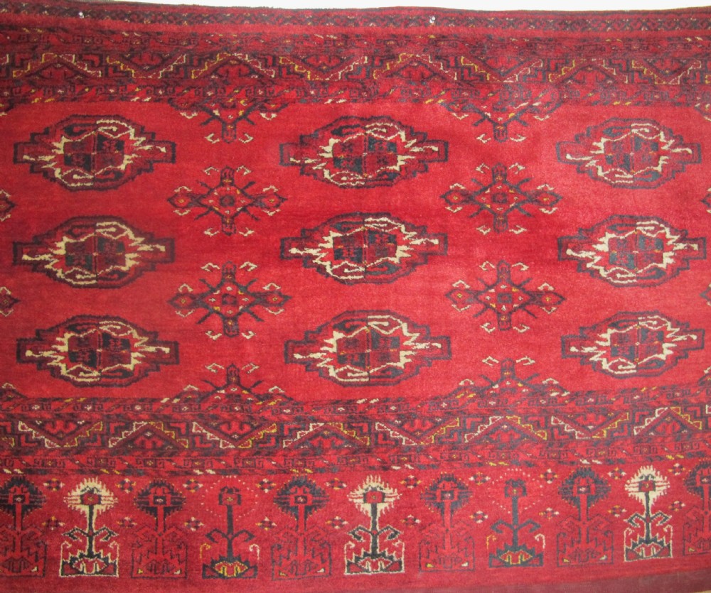 A rectangular hand-knotted red wool Ersari chuval featuring octagonal gol motifs, geometric borders, and a decorative lower panel. View II