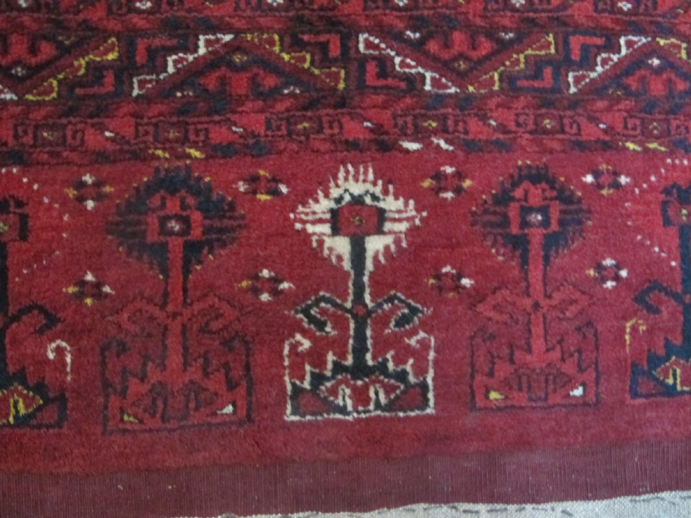 A rectangular hand-knotted red wool Ersari chuval featuring octagonal gol motifs, geometric borders, and a decorative lower panel. View VIII