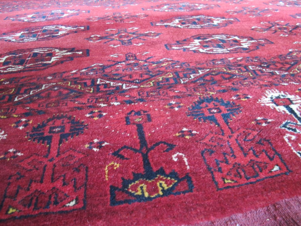 A rectangular hand-knotted red wool Ersari chuval featuring octagonal gol motifs, geometric borders, and a decorative lower panel. View IX