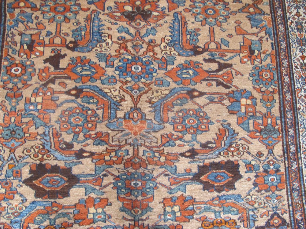 An antique hand-knotted Hamadan carpet featuring intricate geometric and floral patterns in terracotta, indigo blue, and tan hues. View III