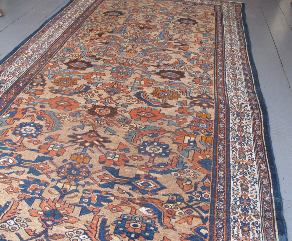 An antique hand-knotted Hamadan carpet featuring intricate geometric and floral patterns in terracotta, indigo blue, and tan hues. View V