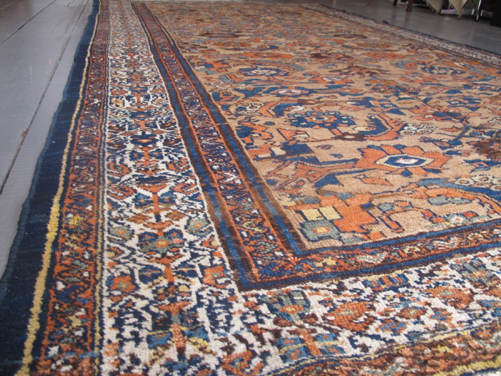 An antique hand-knotted Hamadan carpet featuring intricate geometric and floral patterns in terracotta, indigo blue, and tan hues. View VI
