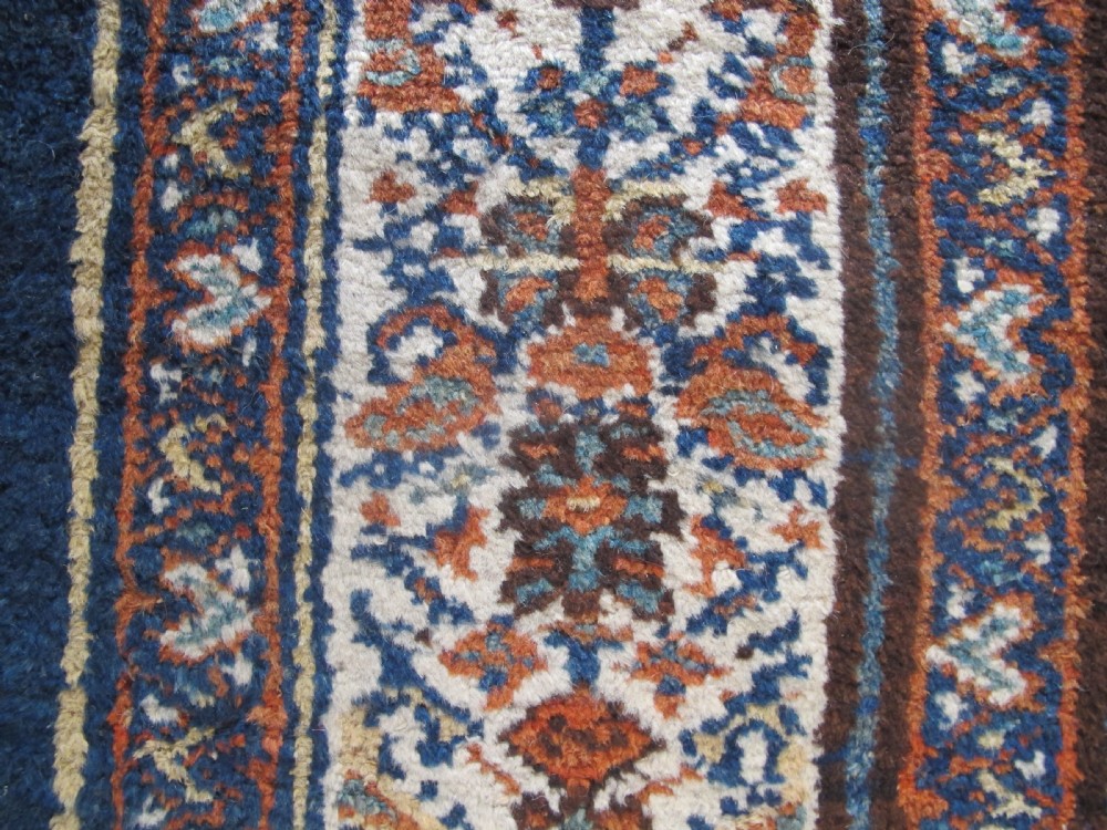 An antique hand-knotted Hamadan carpet featuring intricate geometric and floral patterns in terracotta, indigo blue, and tan hues. View VIII