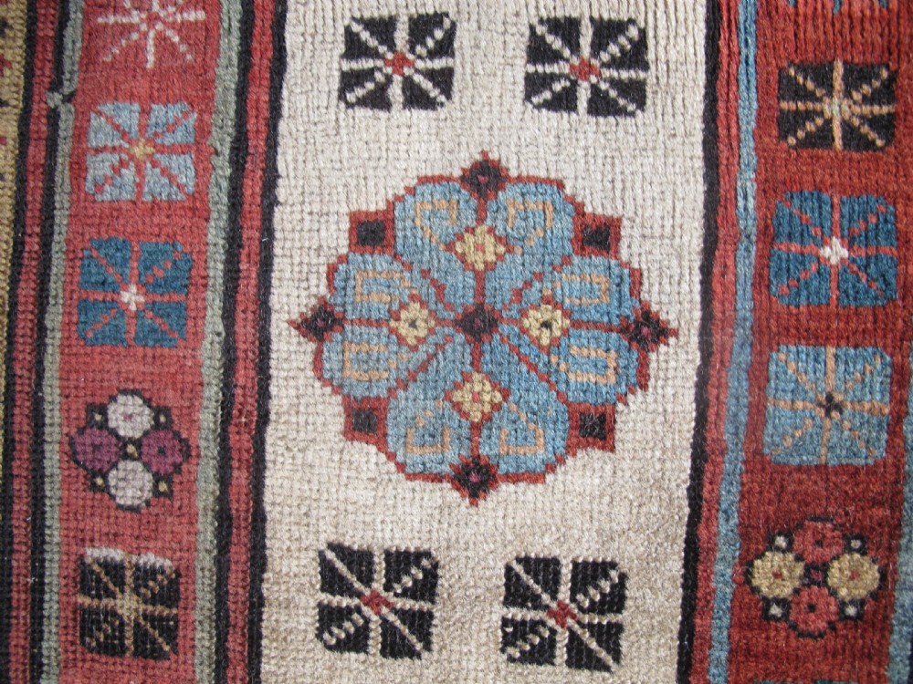 An antique Caucasian Talish hand-knotted wool long rug featuring a light blue central field with geometric motifs bordered by ivory and red patterned bands. View V