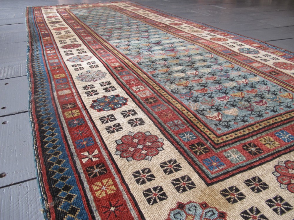 An antique Caucasian Talish hand-knotted wool long rug featuring a light blue central field with geometric motifs bordered by ivory and red patterned bands. View VI