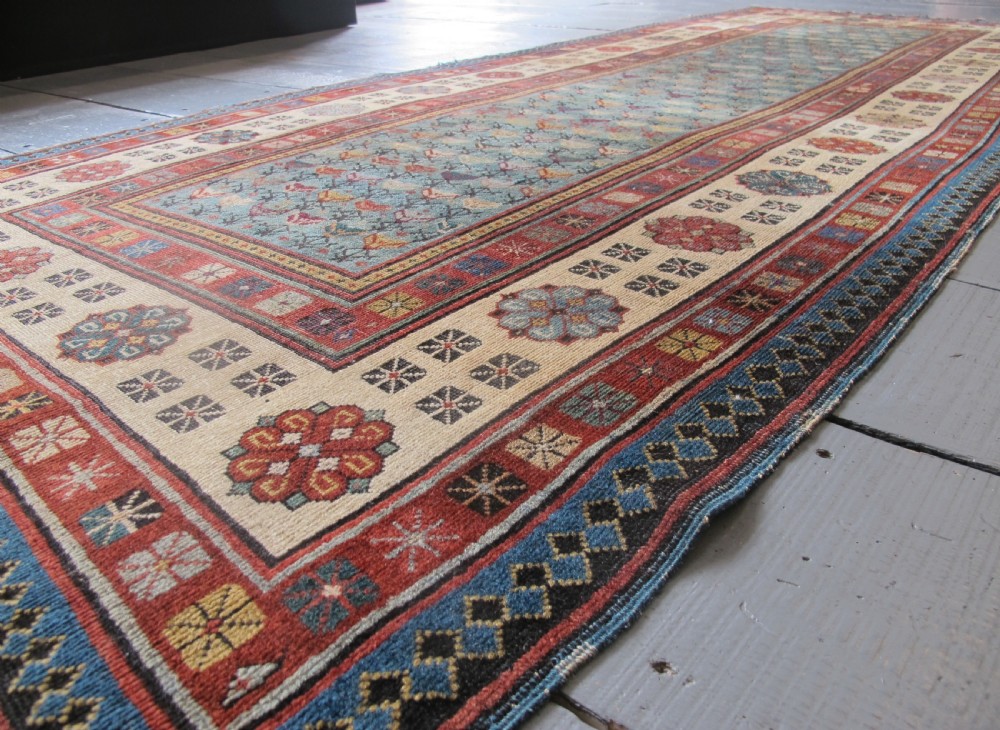 An antique Caucasian Talish hand-knotted wool long rug featuring a light blue central field with geometric motifs bordered by ivory and red patterned bands. View VII