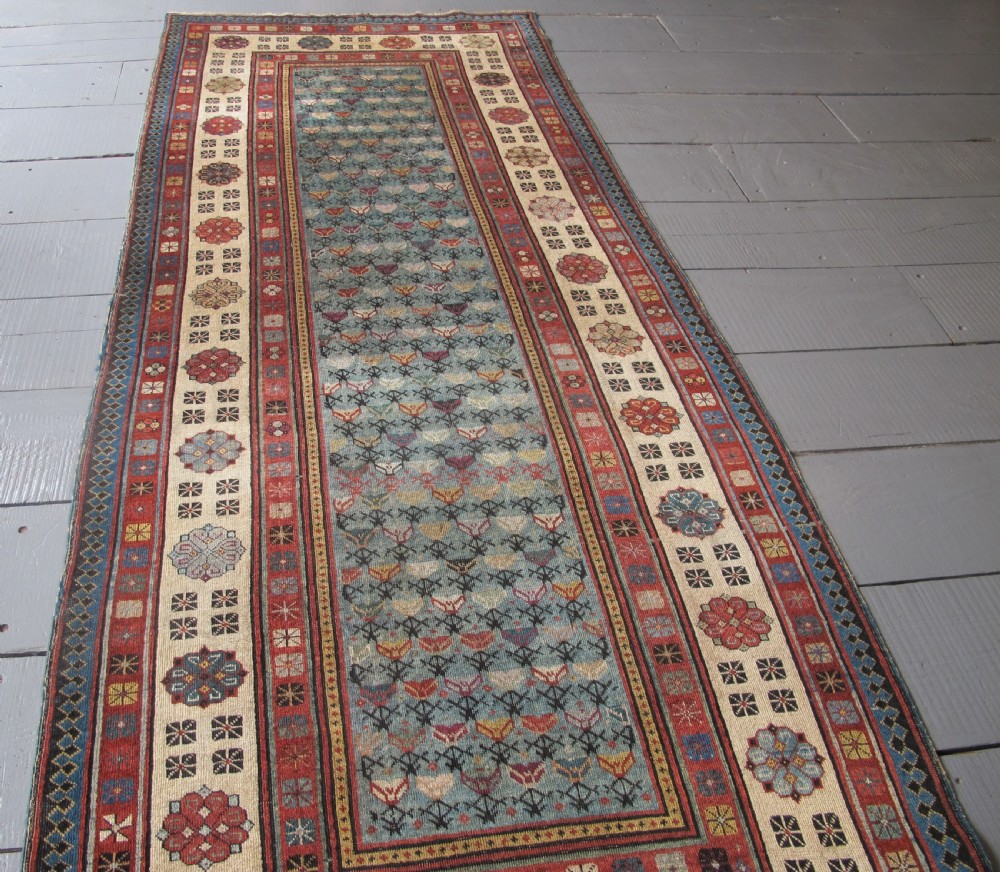 An antique Caucasian Talish hand-knotted wool long rug featuring a light blue central field with geometric motifs bordered by ivory and red patterned bands. View VIII