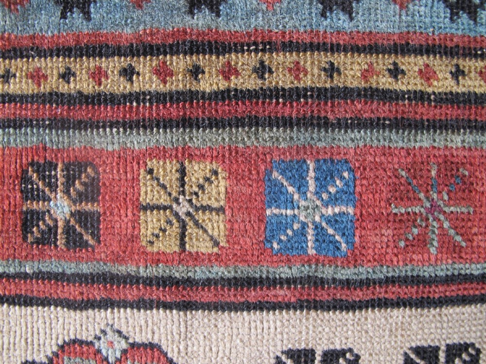 An antique Caucasian Talish hand-knotted wool long rug featuring a light blue central field with geometric motifs bordered by ivory and red patterned bands. View IX
