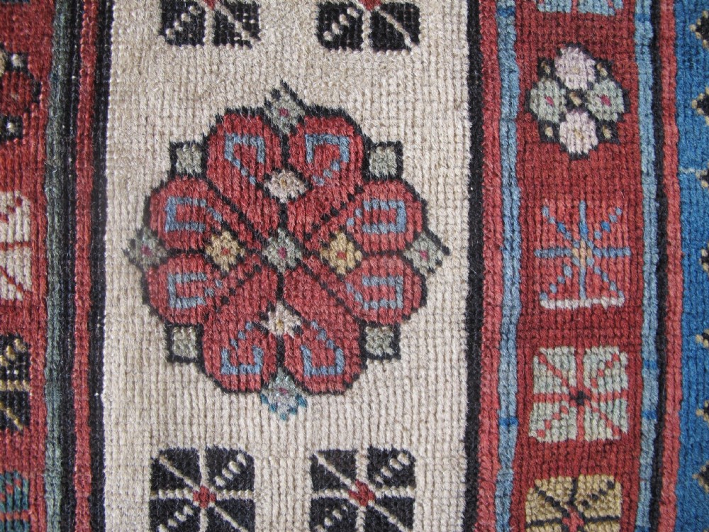 An antique Caucasian Talish hand-knotted wool long rug featuring a light blue central field with geometric motifs bordered by ivory and red patterned bands. View X