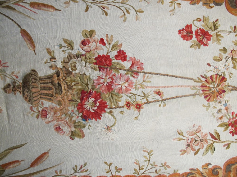 A tall, narrow 19th-century French Aubusson woven tapestry featuring a hanging floral basket, urn motifs, and rocaille border designs on a beige ground. View IV