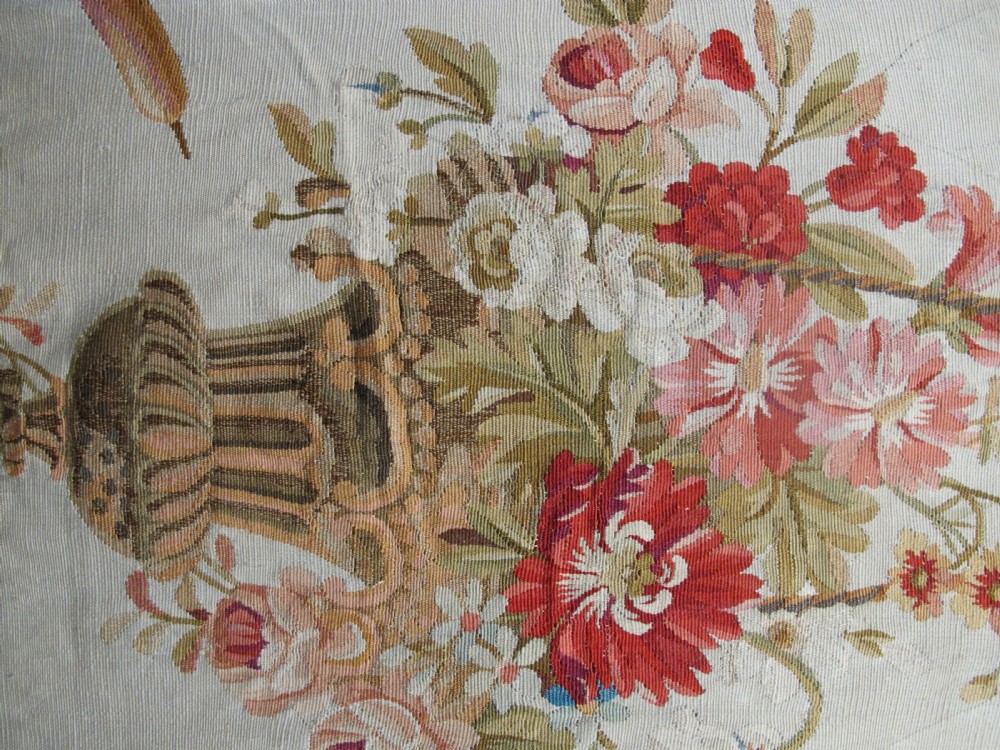 A tall, narrow 19th-century French Aubusson woven tapestry featuring a hanging floral basket, urn motifs, and rocaille border designs on a beige ground. View V