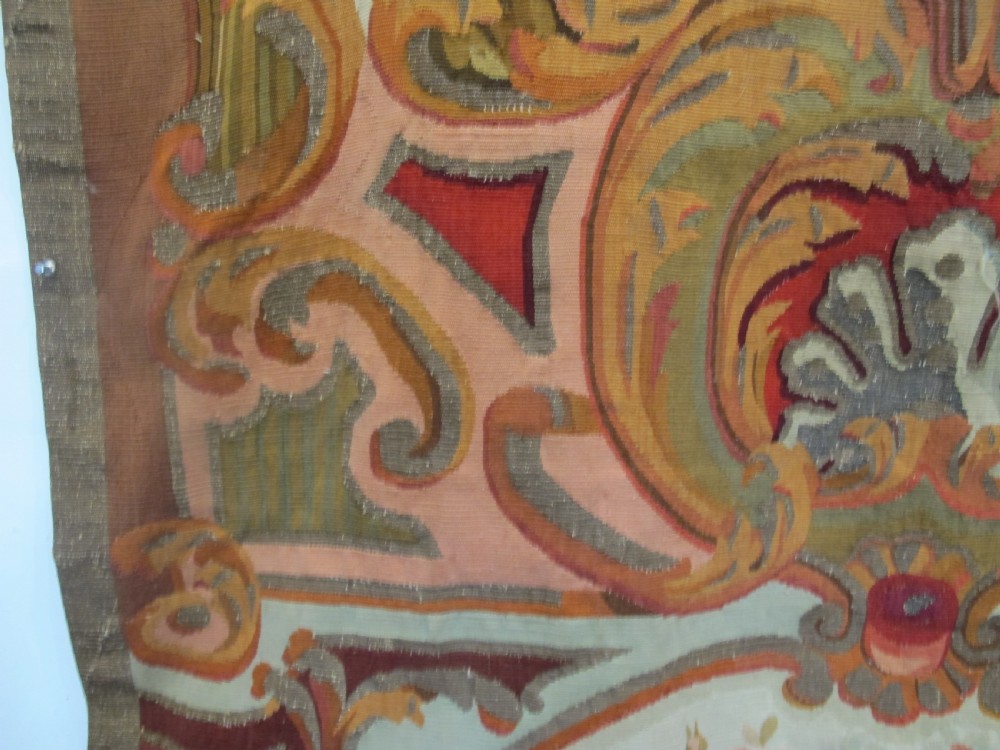 A tall, narrow 19th-century French Aubusson woven tapestry featuring a hanging floral basket, urn motifs, and rocaille border designs on a beige ground. View IX