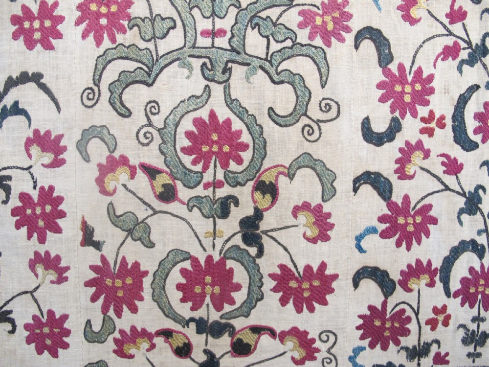 A large rectangular Central Asian suzani textile featuring repeating vertical columns of red embroidered floral motifs on a natural beige cotton substrate. View II